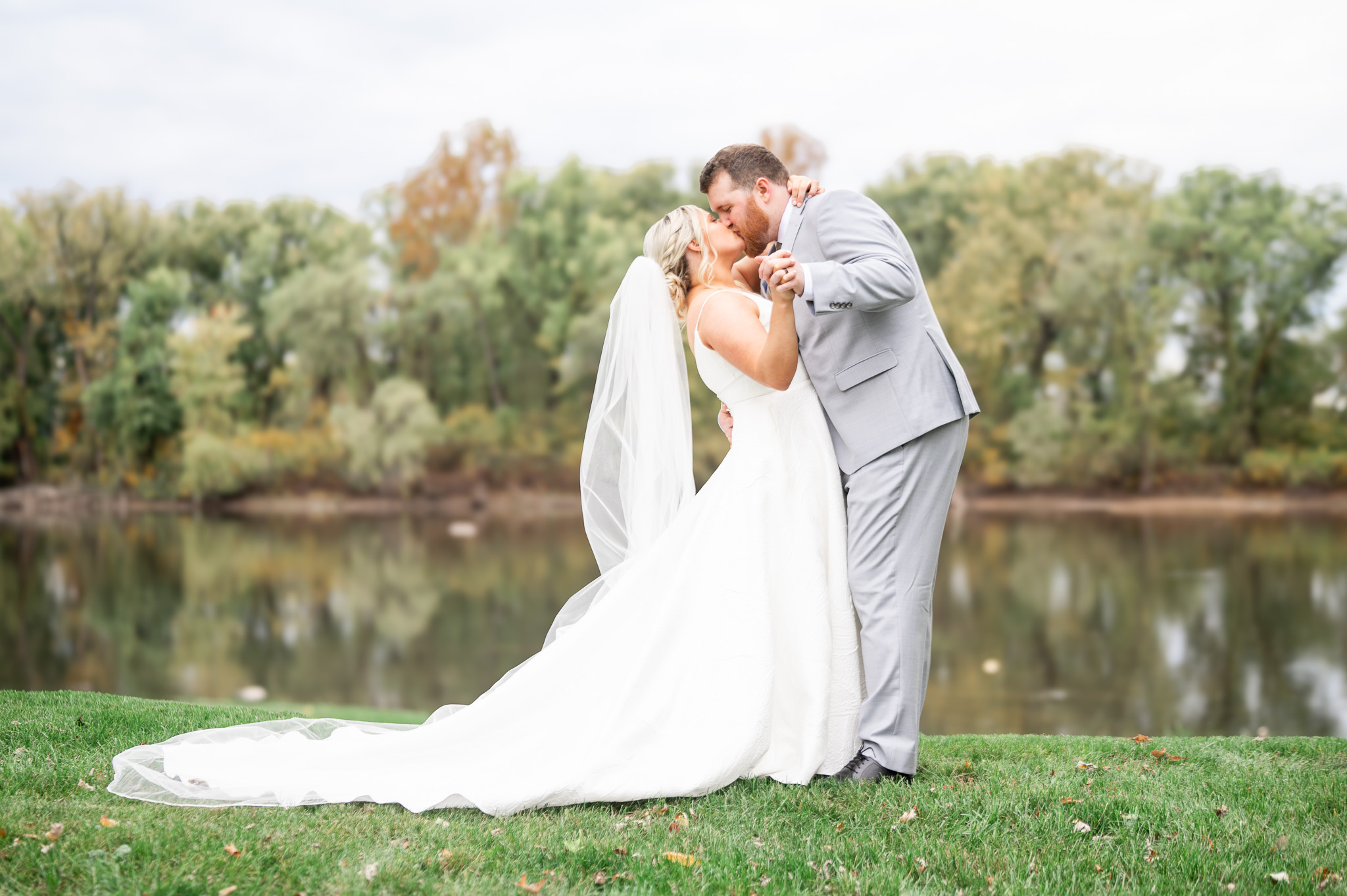 Newlyweds sharing a kiss by the Susquehanna River at River Bend Wedding Venue in Millersburg PA